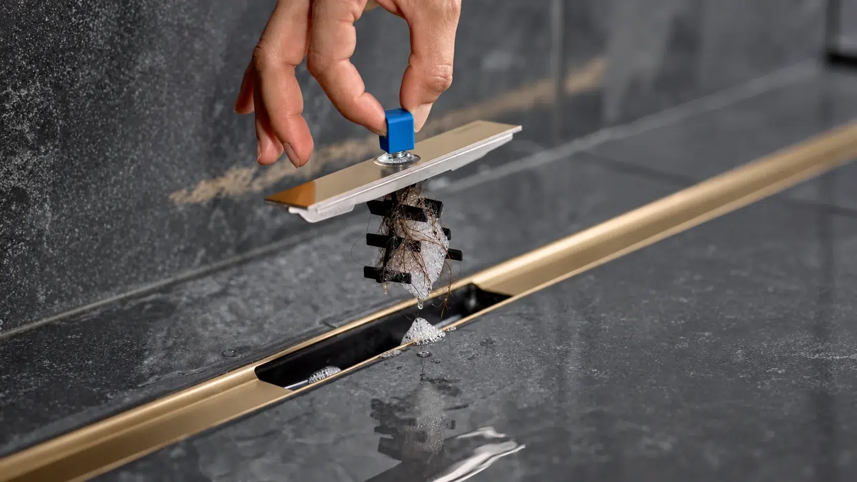 Retrait du filtre à cheveux d'un caniveau de douche Geberit CleanLine pour nettoyer l'évacuation et prévenir les bouchons.